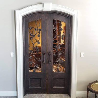 iron double entry door with arched top and exquisite scrollwork